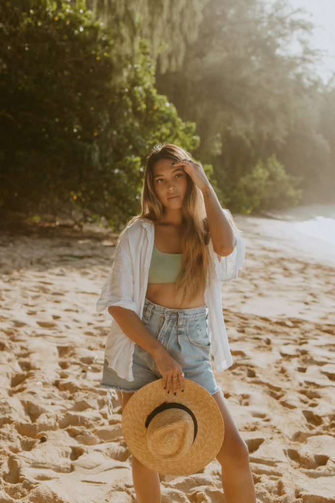model is standing on the beach looking gracefully into the distance