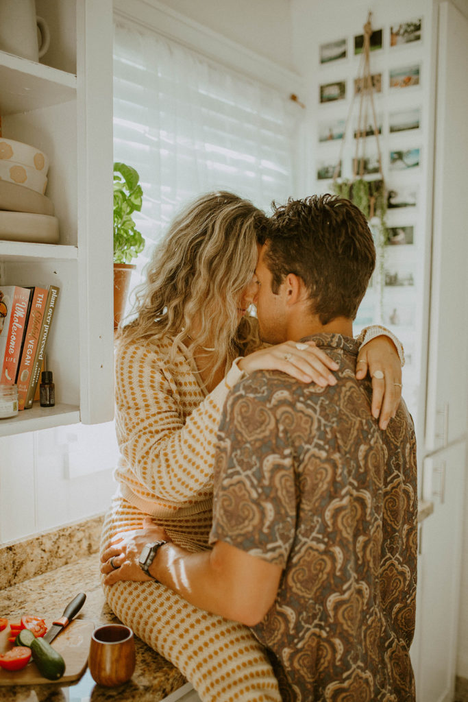 Couple is looking intimately at each other while sitting on counter