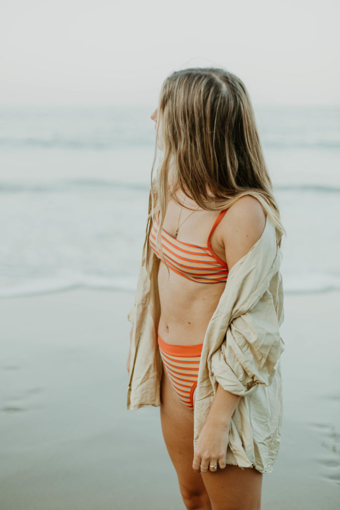 portrait shot of bree in her swimsuit looking towards the ocean