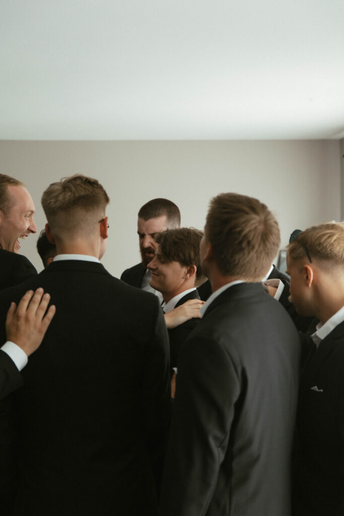 Groomsmand party praying over groom