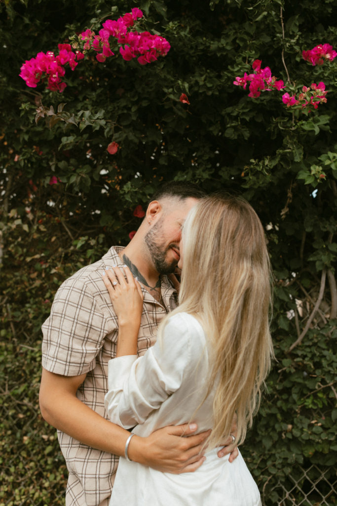 couple is about to kiss under a flower tree