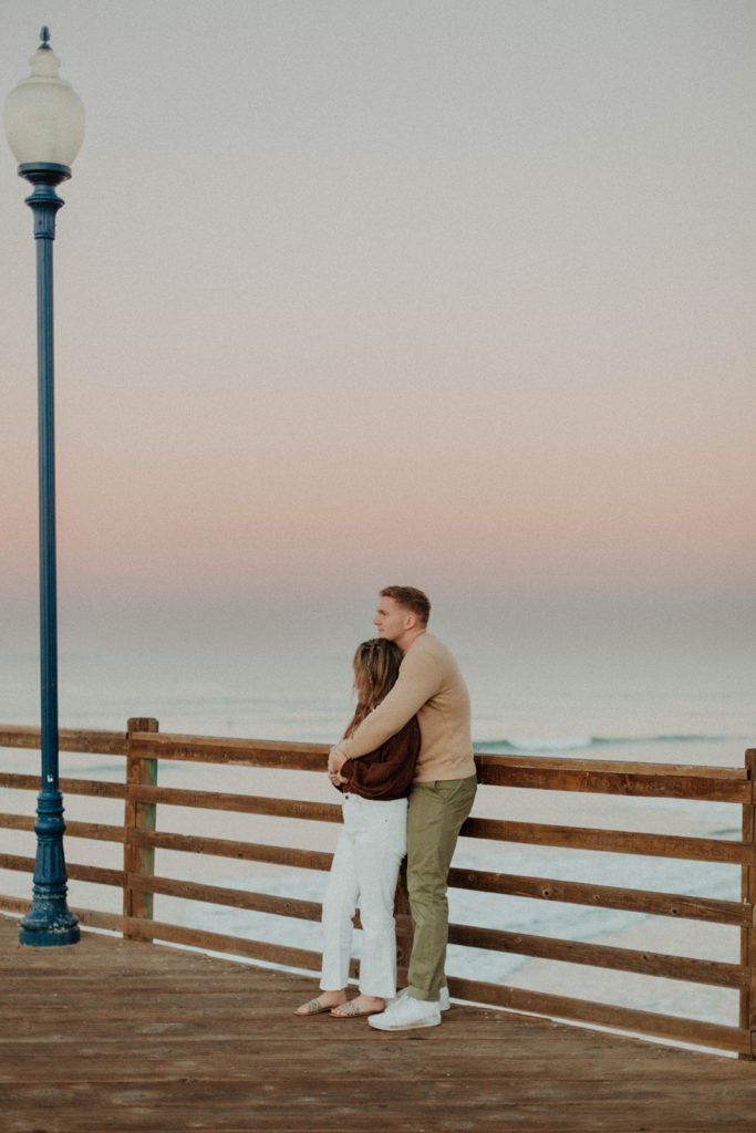 shot of the couple standing on the pier