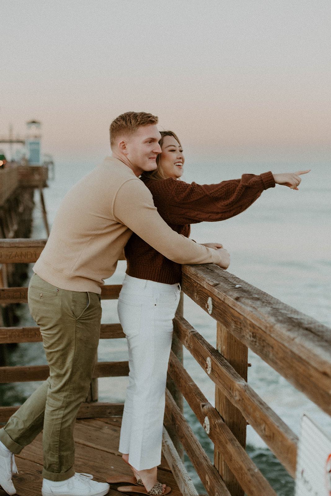 shot of daniel leaning behind julianna as she points towards the ocean