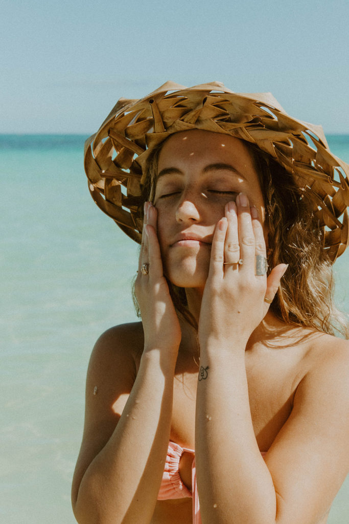 portrait of model rubbing product into her skin