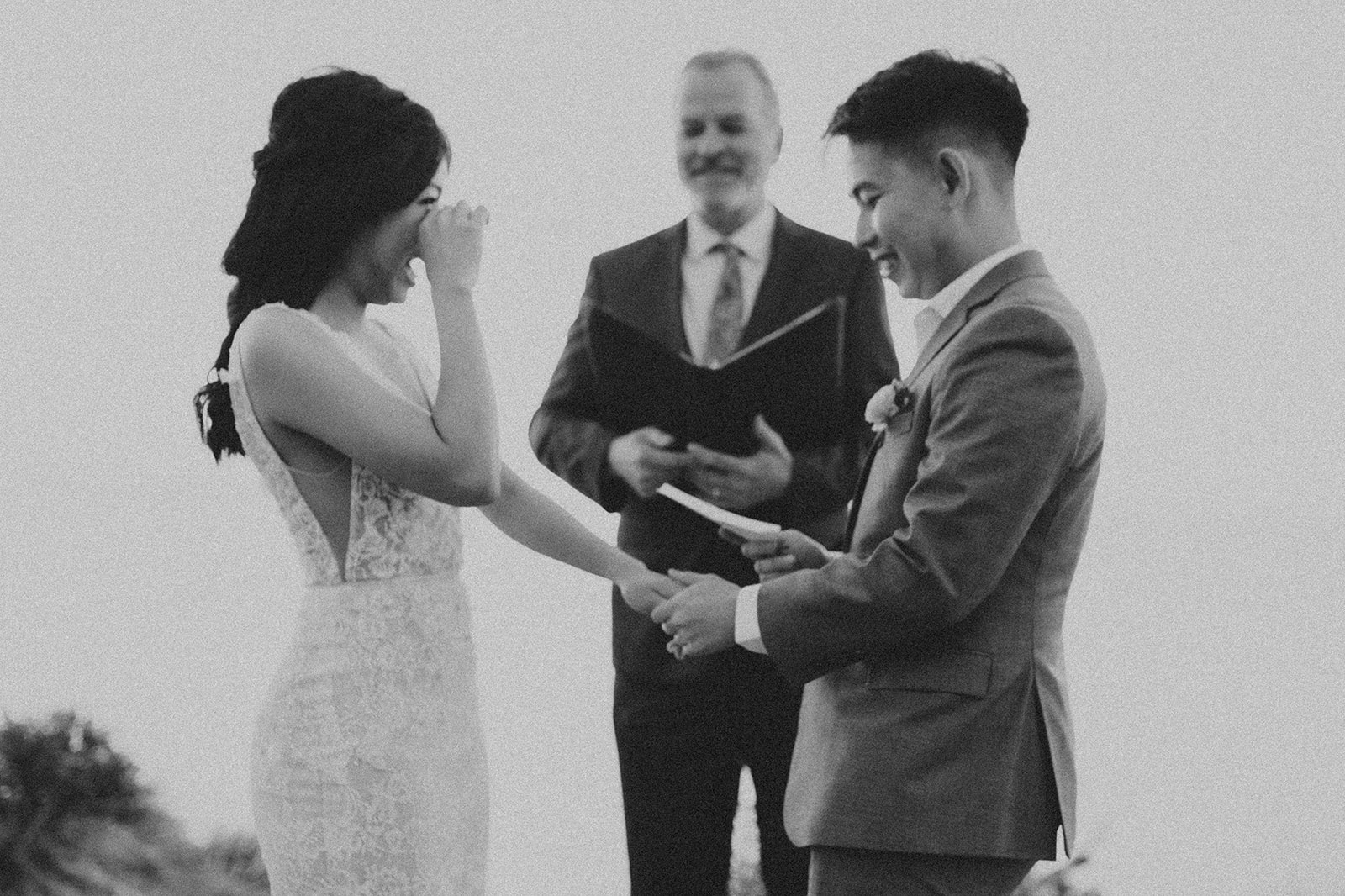 black and white picture of greg putting the wedding band on JieYis finger