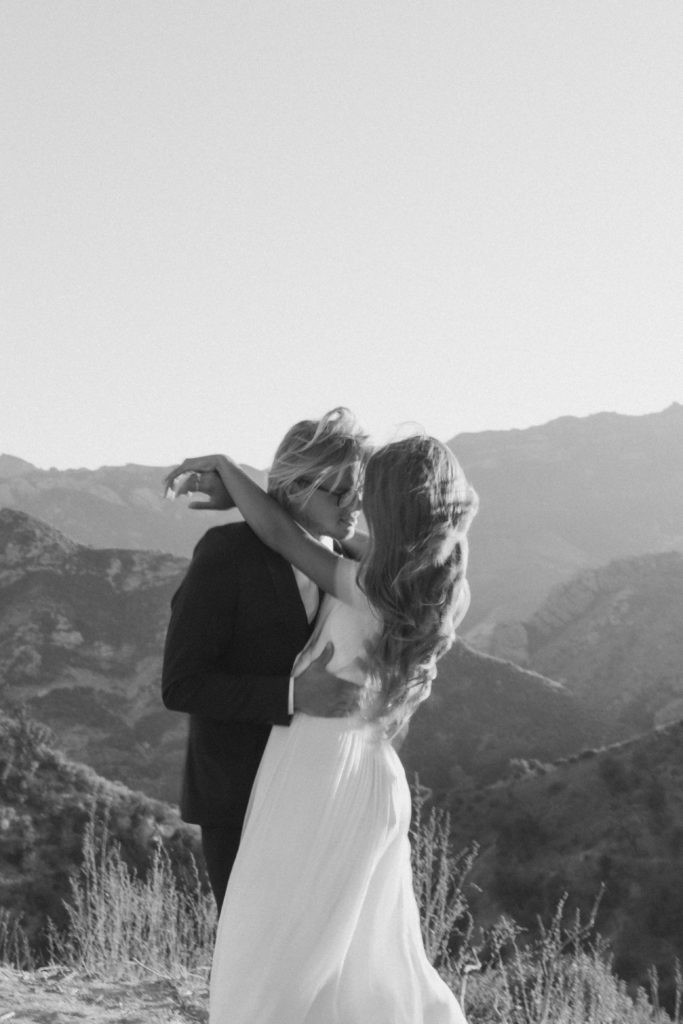 black and white wedding portraits of the couple leaning in to kiss each other