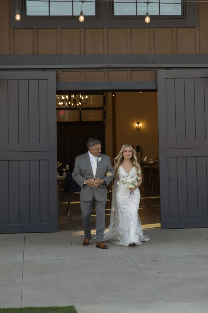 bride walking hand in hand with father down the aisle at Knoxville wedding venue 