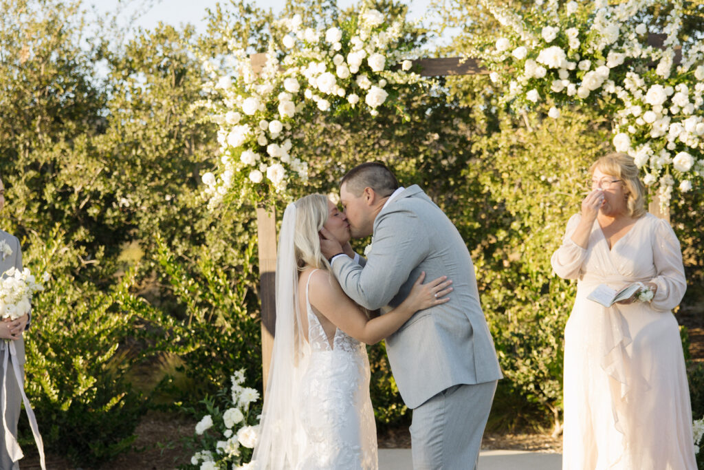 Bride and groom kissing at the end of wedding ceremony 