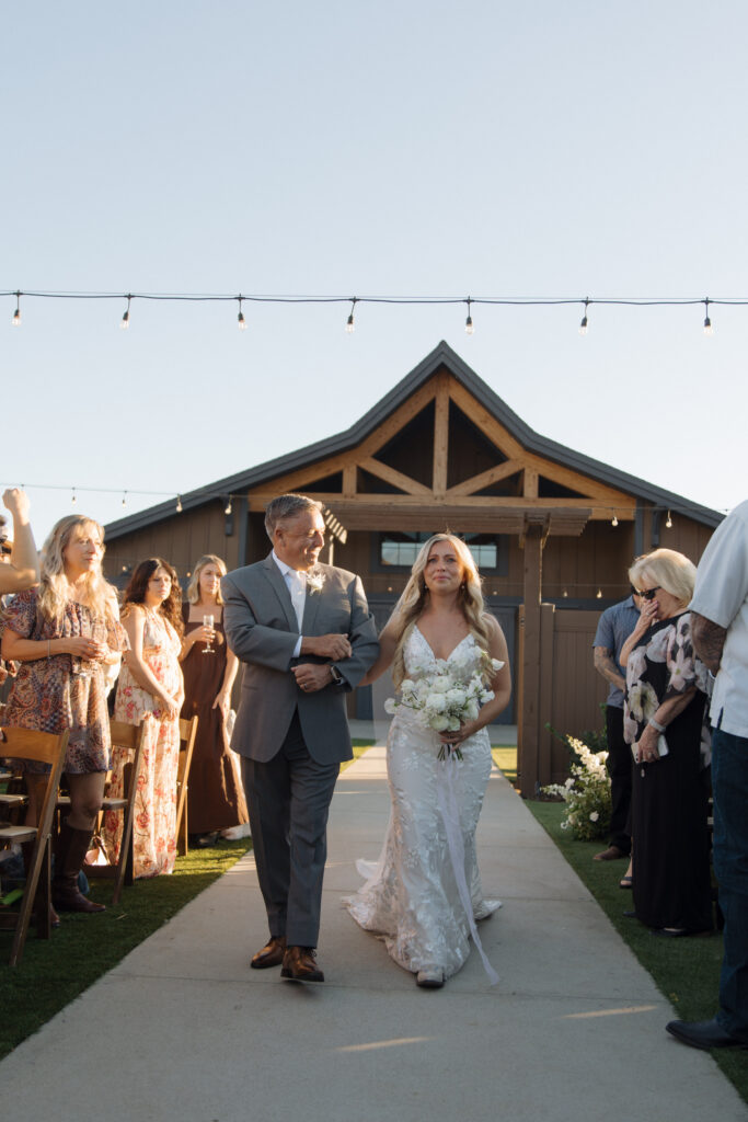 bride walking hand in hand with father down the aisle at Knoxville wedding venue 