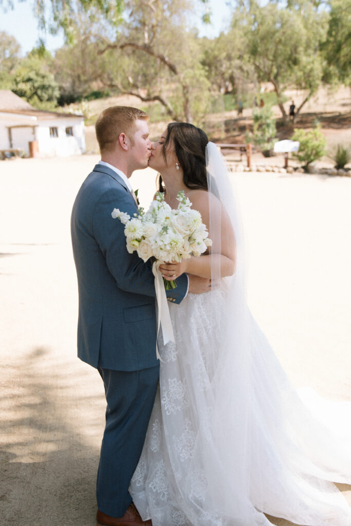 bride and groom kissing at first look